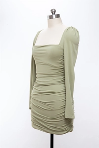 Détail de la robe moulante vert sauge avec col carré et texture de tissu froncée