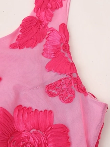 Macro shot of 3D floral embroidery and mesh fabric on a pink summer vacation dress