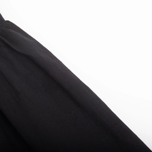 Close-up of the black cotton fabric showing fine woven texture and soft draping details