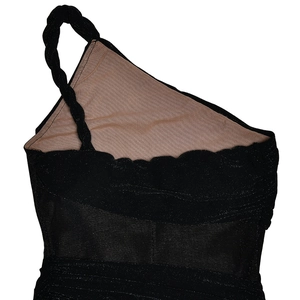 Detail of black one-shoulder dress with woven strap and shimmering textured fabric