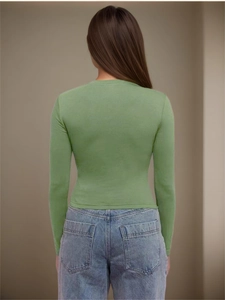 T-shirt manches longues vert herbe moulant pour femme avec jean bleu clair vue de dos