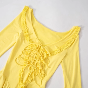 Detail of bright yellow off-shoulder top with ruffle neckline and lace-up front detail