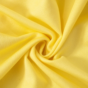 Detailed macro view of bright yellow woven polyester fabric texture on summer dress