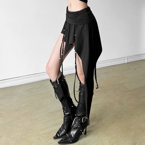 Detail of black irregular skirt featuring metal bead accents and pleated waist design