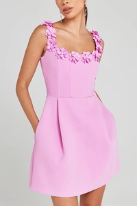 Détail d'appliques florales 3D et de perles sur une robe caraco courte rose