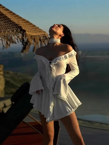 White off-shoulder bohemian dress with ruffled V-neck and flared sleeves in sunset scene
