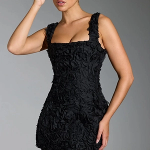 Close-up detail of 3D rose petal texture on a black bodycon cocktail party dress
