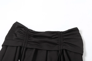 Detailed macro view of the ruched waist design and adjustable drawstrings on a black skirt