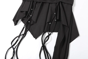 Detail of black irregular hem skirt with draping ties and silver metal bead accents