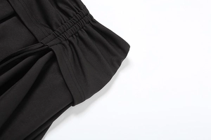 Detailed close-up showing elastic ruched waist and soft fabric of the black skirt