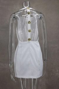 Close-up of open back dress with vertical white straps and golden camellia buttons