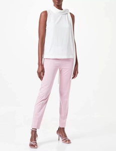 Détail du haut en mousseline blanche sans manches avec nœud et pantalon rose élégant
