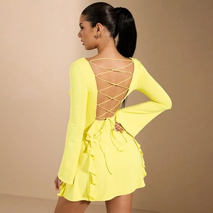Détail de la robe jaune fluo avec dos nu à lacets croisés et ourlet à volants