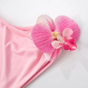 Detailansicht eines rosa Kleides mit großer 3D-Orchideenblüte und realistischer Textur