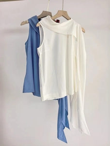 Détail de hauts sans manches en mousseline bleu clair et blanc cassé avec col écharpe