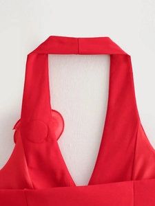 Detail of red halter neck top with deep V-neckline and 3D floral accent on shoulder