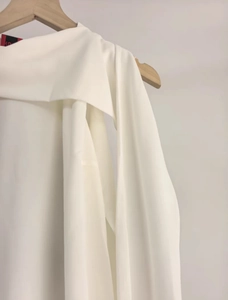 Détail d'un haut sans manches en mousseline blanche avec nœud et texture drapée