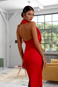 Détail d'une robe de soirée dos nu rouge en satin avec une fente arrière élégante