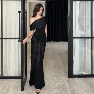 Detail of the elegant waist-tie design on a sleek one-shoulder black evening gown