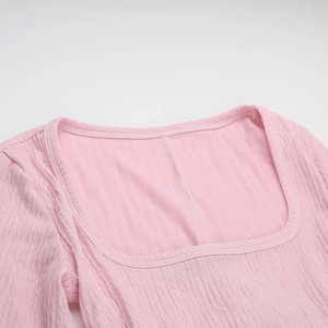 Close-up of the square neckline and light pink crinkle texture fabric on this dress