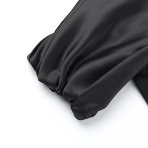 Detailed macro view of gathered black satin cuffs with elegant lantern sleeve textures