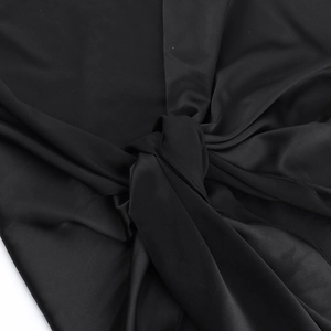 Detailed view of the elegant black mesh shoulder strap knot on the slim evening dress