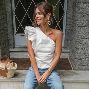 Detailed view of white one-shoulder ruffled cotton vest with asymmetric layered design
