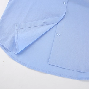 Detail of light blue shirt-tail hem with neat stitching and matching buttons