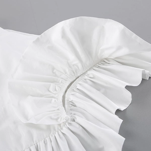 Macro shot of delicate white cotton ruffle edge detailing with fine stitching craftsmanship