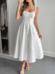 Détail de robe longue blanche en jacquard avec décolleté en cœur et fines bretelles