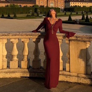 Detailed close-up of wine red evening dress featuring black lace V-neck and trumpet sleeves
