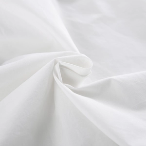 Macro shot of white cotton fabric showing detailed texture and elegant pleated ruffles