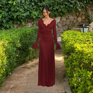 Detail of wine red V-neck dress with delicate lace trim and double ruffled cuffs