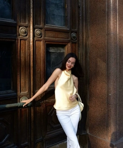 Détail du haut dos nu en satin jaune pâle avec col drapé et texture soyeuse élégante