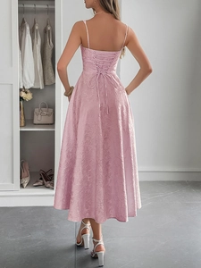 Détail de la robe longue jacquard rose montrant les bretelles croisées et le tissu fleuri