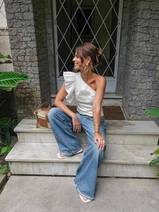 French vintage one-shoulder white cotton top with ruffles and blue wide-leg jeans