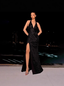 Sparkly black halter neck evening dress with deep V-neck and sexy high side slit