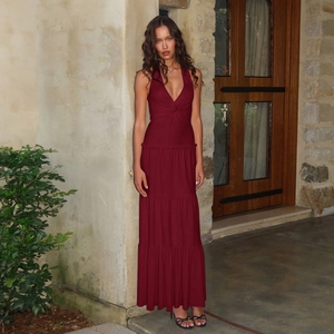Detail of burgundy halter neck maxi dress with tiered skirt and elegant open back design