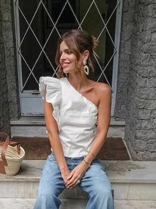 Elegant white one-shoulder ruffled cotton vest paired with jeans for a summer look