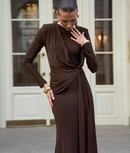Detail of asymmetric pleats and waist twist on chocolate brown long-sleeve maxi dress