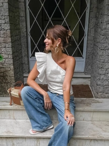 French vintage white one-shoulder ruffle top paired with wide-leg denim jeans