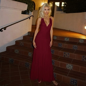 Detail of burgundy V-neck tiered maxi dress with metallic shoulder accents in night setting