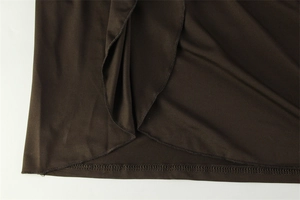 Détail de l'ourlet de robe marron foncé avec des volants doux et des coutures précises