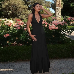 Detail of elegant black halter neck maxi dress with deep V-neck and tiered skirt design