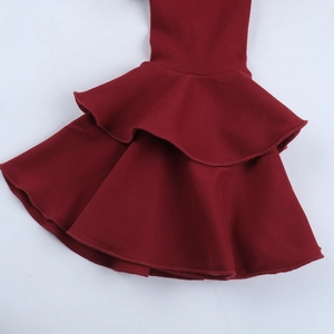 Close-up detail of burgundy V-neck dress featuring layered ruffle sleeve hem and knit texture