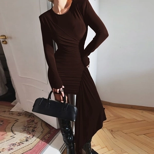 Detail of slim-fit brown ruched dress with asymmetrical draped fabric and shoulder pads