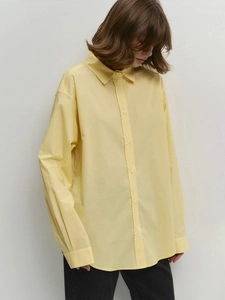 Women's minimalist loose yellow cotton shirt with classic button-down collar and curved hem