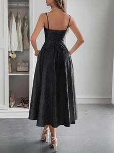 Détail du laçage style corset au dos d'une robe noire en tissu jacquard