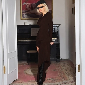 Detail of slim fit dark brown long sleeve dress with asymmetric pleated skirt and ruching