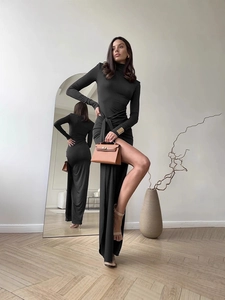 Robe noire ajustée à col roulé avec nœud latéral et fente haute sur le côté